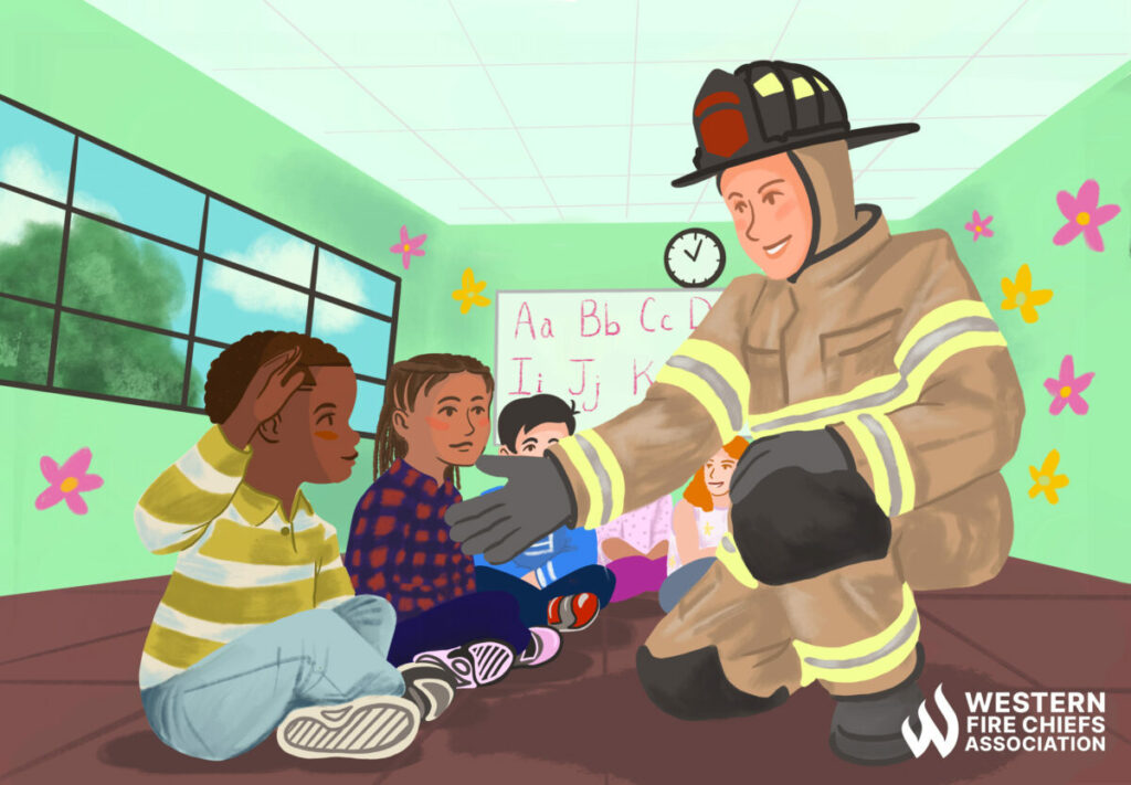 A firefighter in full protective gear holds out a hand to a young child seated on the floor of a classroom. Other children sit nearby.